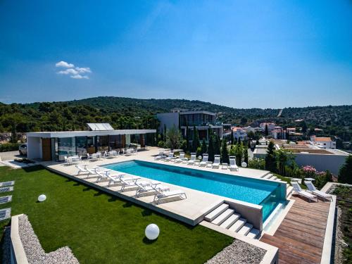 a swimming pool with lounge chairs and a building at Golden Rays Luxury Villas & Apartments in Primošten