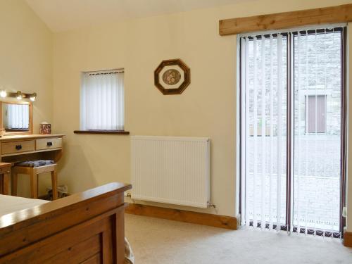 a room with a radiator and a large window at The Old Byre in Dearham