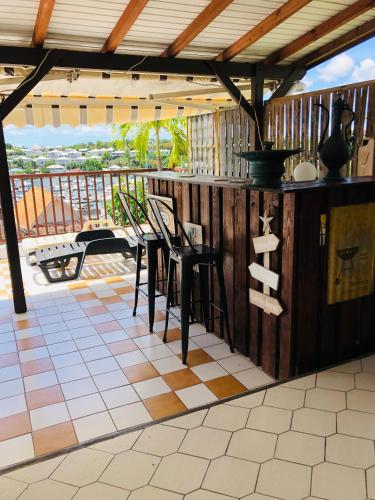 a patio with chairs and a counter with a view at Chambre d'Hôtes Caïpi in Le Gosier