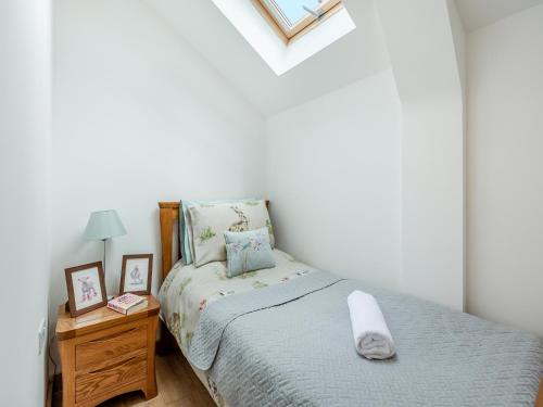 a small bedroom with a bed and a night stand at Old Highwood - Piggy In The Middle in Luppitt