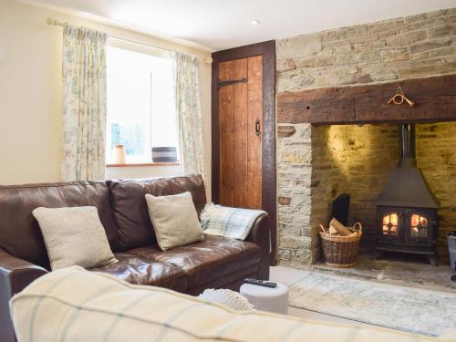 a living room with a leather couch and a fireplace at Herrock View in Evenjobb