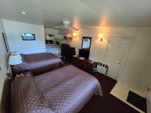 a hotel room with two beds and a mirror at Lake View Motel in Cooperstown