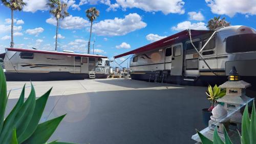 two rvs parked in a parking lot with palm trees at Retro Star-Wagon, Ocean Breez at Dolby Sound Studio in Oceanside