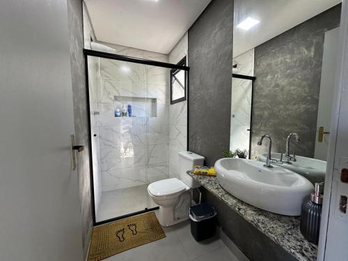 a bathroom with a sink and a toilet and a shower at Casa Malu in Bertioga
