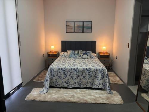 a bedroom with a bed with two night stands and two lamps at Casa Malu in Bertioga