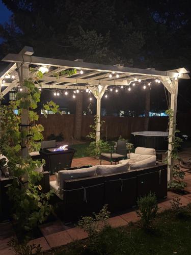 a pergola with lights and a couch in a yard at The Cozy nest in Englewood