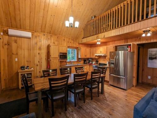 a kitchen with a table and chairs and a refrigerator at Relax On the Lake Waterfront with Hot Tub in Chertsey
