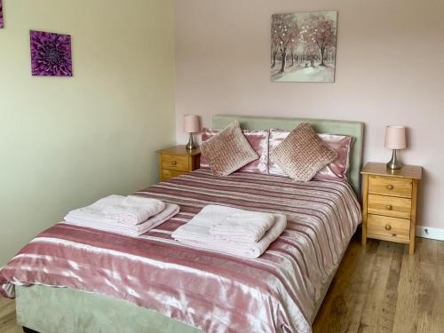 a bedroom with a large bed with two night stands at Green Valley Retreat in Holsworthy