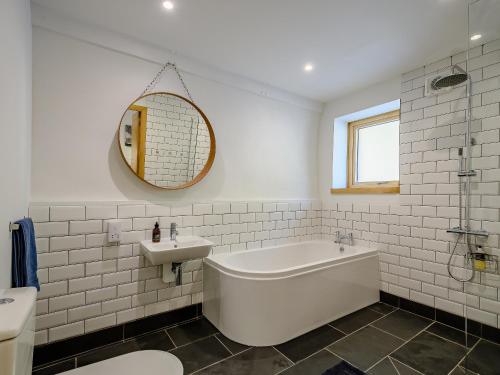a white bathroom with a tub and a sink at Jack Strawbale House - Uk7521 in Strontian