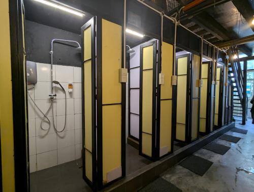 a bathroom with yellow and white walls and a shower at Mingle Highstreet - CoWorking Hub in Kuala Lumpur
