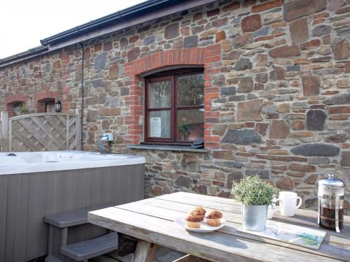 a table with some donuts on it in front of a stone building at The Old Mill House in Welcombe