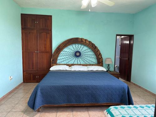 a bedroom with a large bed with a blue wall at Casa Fátima in Tequesquitengo