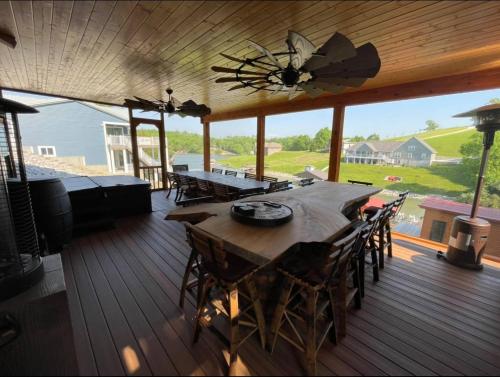 a wooden deck with a table and chairs on it at Lake Therapy at The ARK | Gameroom, Hot Tub, Dock in Williamstown