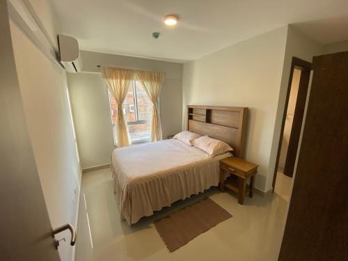 una piccola camera da letto con un letto e una finestra di Encantador apartamento de 2 dormitorios a Luque