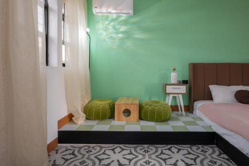 a bedroom with a bed and two green pillows at Hotel Asia Star in Mérida
