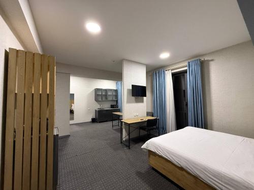 a hotel room with a bed and a desk with a computer at Premium 777 Hotel in Yakkasaray