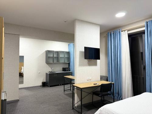 a hotel room with a bed and a desk and a kitchen at Premium 777 Hotel in Yakkasaray