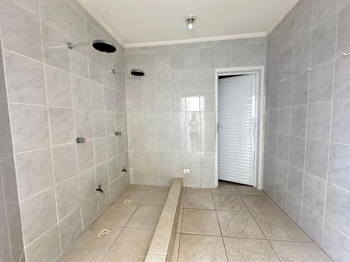 ein Badezimmer mit ebenerdiger Dusche und einer Tür in der Unterkunft Apto c/ vista mar e piscina no prédio perto do mar in Samaritá
