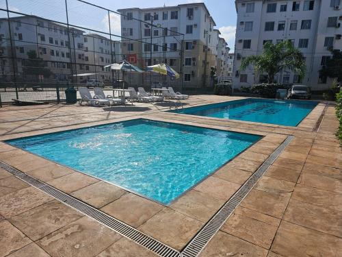 una piscina con agua azul en un edificio en Acomodação Ideal Samambaia, en Ananindeua