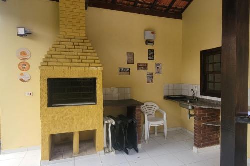 cocina con chimenea, mesa y sillas en PeruíBella Pousada, en Peruíbe