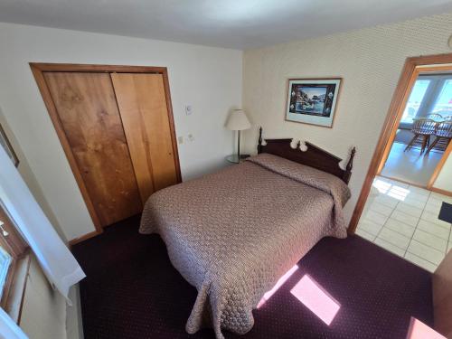 a small bedroom with a bed and a window at Lake View Motel in Cooperstown
