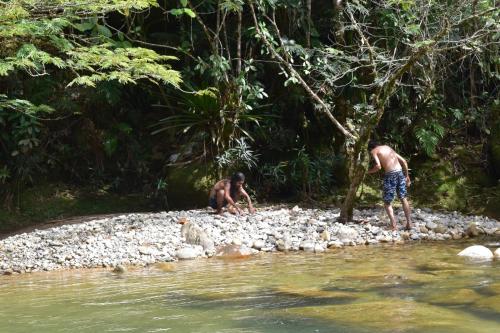 two men playing on the rocks in a river at La embajada mágica in San Rafael