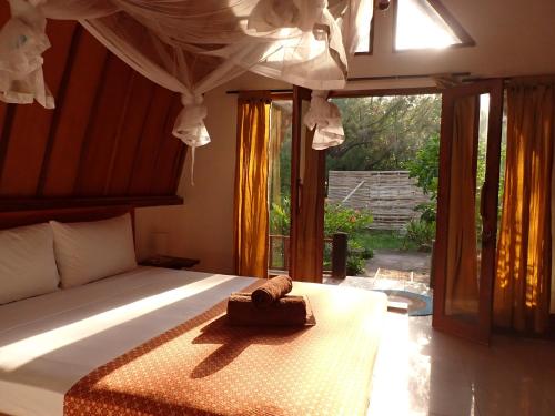 a bedroom with a bed with a box on it at Rising Sun Bungalows in Gili Meno