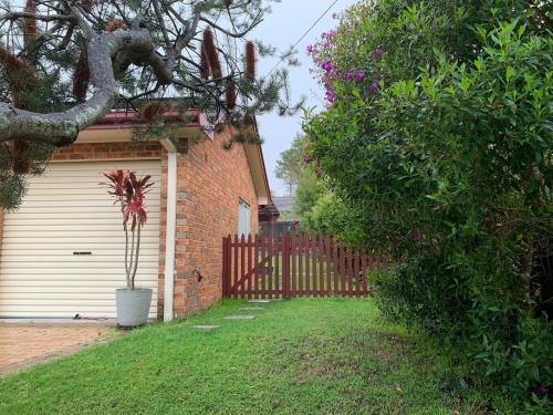 a house with a fence and a plant in a yard at Fabulous Stunning Garden View King Bedroom with shared bathroom at MC 2079 in Mount Colah