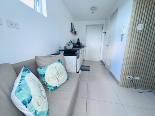 大雅台Condo Unit at Cool Suites SMDC Wind Tagaytay的客厅里有一张沙发和一个厨房