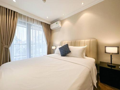 a bedroom with a large white bed with a window at Skyline Tower - Service Apartments in Hanoi