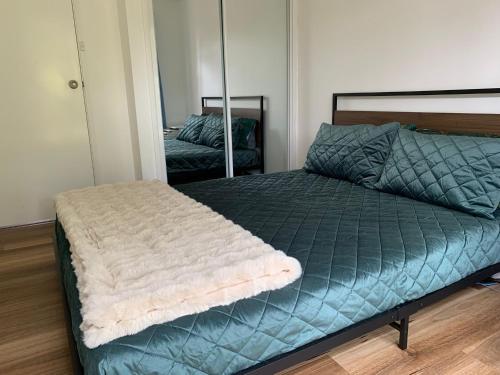 1 dormitorio con cama verde y espejo en Amazing Stunning Garden View Queen Bedroom at MC 2079, en Mount Kuring-Gai