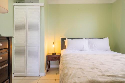 a bedroom with a bed and a table with a lamp at Musgrave AnneX- comfy 1 bedroom apartments in Kingston