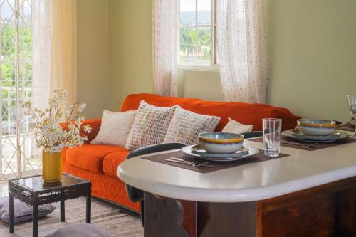 a living room with an orange couch and a table at Musgrave AnneX- comfy 1 bedroom apartments in Kingston