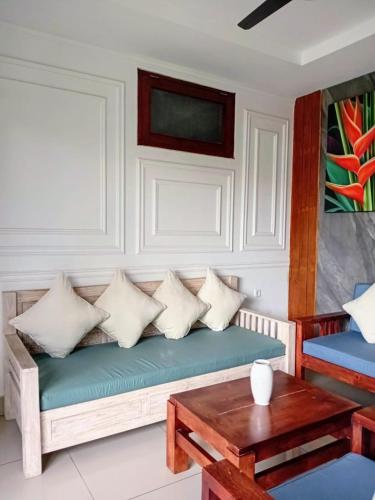eine Couch mit Kissen und einem Tisch in einem Zimmer in der Unterkunft Casa Green Kori in Kerobokan