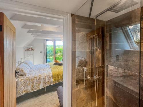 a bedroom with a bed and a glass shower at Wysteria, North Lodge in Rusper