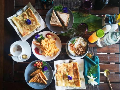 a table with plates of food on a table at Le Panpurie Koh Lanta Resort in Ko Lanta Yai