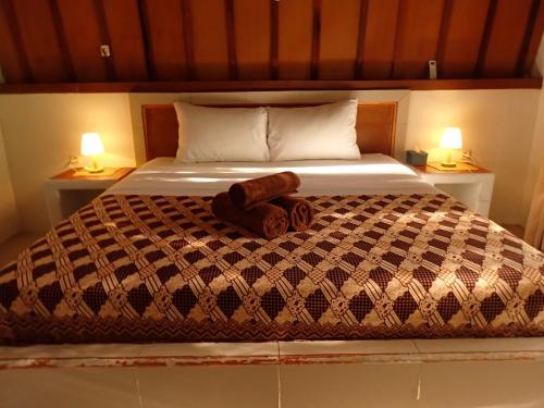 a bed with a stuffed animal laying on it at Rising Sun Bungalows in Gili Meno