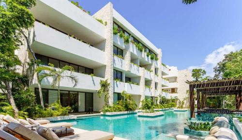 an exterior view of a hotel with a swimming pool at Relaxing 2BR Condo Omara with Direct Pool Access in Tulum