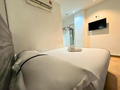 a hospital bed with a white blanket on it at Smile Hotel Damansara Tropical in Petaling Jaya