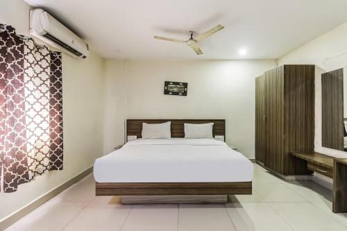 a bedroom with a large bed in a room at Hotel O Thilothama Grand in Vijayawāda