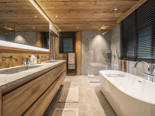 a bathroom with two sinks and a bath tub at Appartement haut de gamme à Courchevel Le Praz avec parking et wifi - FR-1-568-58 in le Praz