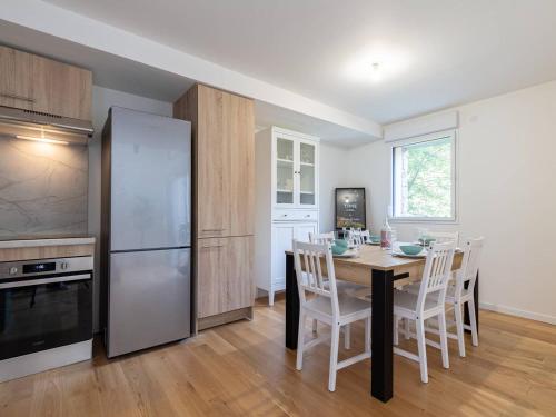 a kitchen with a table with chairs and a refrigerator at Duplex 8 pers à côté Skyvall, Loudenvielle - FR-1-695-88 in Loudenvielle