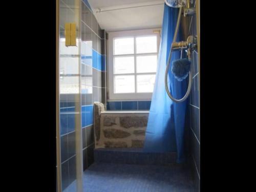 ein Bad mit einer Dusche, einem Fenster und blauen Fliesen in der Unterkunft Gîte convivial à Guérande avec terrasse au calme - FR-1-306-1318 in Clis