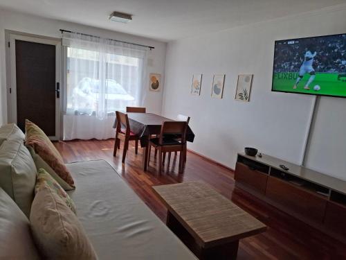 a living room with a couch and a tv and a table at Quinta Luna 10 - Playa Bonita in San Carlos de Bariloche
