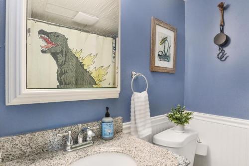 une salle de bain avec un rideau de douche dinosaure et un lavabo dans l'établissement 2 Blocks to the Boardwalk - Panoramic Views of Assateague Island, Bay and Ocean, à Ocean City