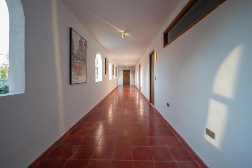 an empty hallway with a tile floor and white walls at Hotel Asia Star in Mérida