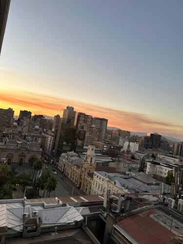 une vue d'une ville au coucher du soleil avec des bâtiments dans l'établissement Departamento Santiago Centro, à Santiago