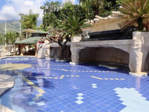 a swimming pool with a blue tile floor and palm trees at Solvae EcoHotel in San Jerónimo