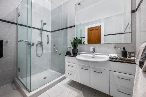a bathroom with a glass shower and a sink at Oh Darling! Auckland CBD Penthouse in Auckland