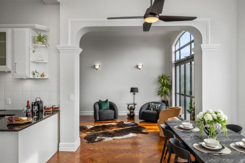 a kitchen and living room with a table and chairs at Oh Darling! Auckland CBD Penthouse in Auckland